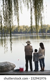 Family Fishing Off A Dock At Lake