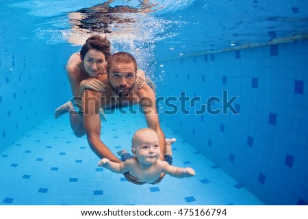 Family fitness - mother, father, baby son learn to swim together, dive underwater with fun in pool Active parent lifestyle, people water sport activity and physical exercises, children swimming lesson