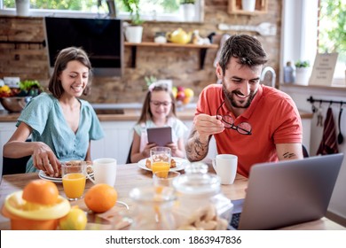 Family, food and happiness concept.Happy mother, father and daughter having breakfast at home.
