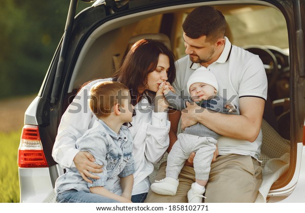Family
in a forest. People by the car. Sunset
background.