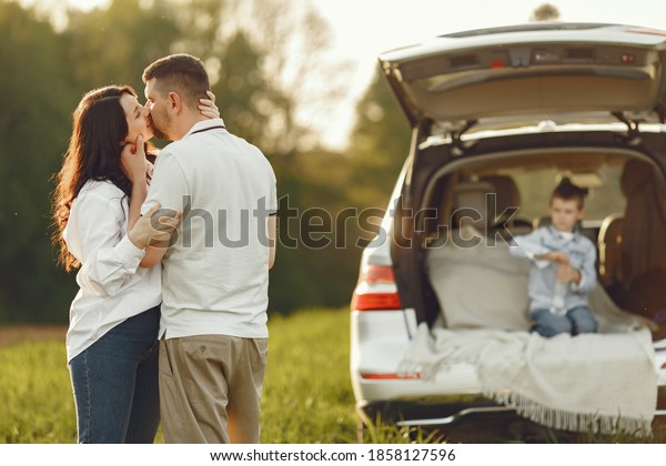 Family\
in a forest. People by the car. Sunset\
background.