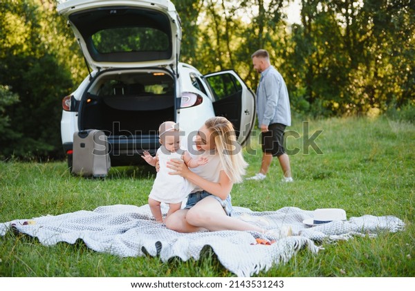 Family
in a forest. People by the car. Sunset
background.