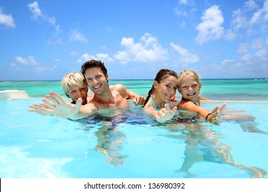 Family of four bathing in swimming pool - Powered by Shutterstock