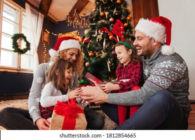 Family of four celebrating Christmas, exchanging presents   - Powered by Shutterstock