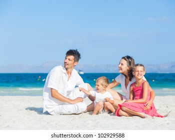 Family of four having fun on tropical beach - Powered by Shutterstock