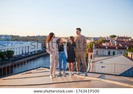 Family of four on rooftop enjoying with view of beautiful sunset in Saint Petersburg in Russia