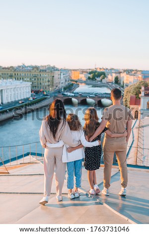 Family of four on rooftop enjoying with view of european city