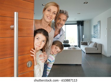 Family Of Four Opening House Front Door