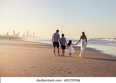 Family of four portrait on the beach, holidays retreat, wellbeing, wellness, mindful concept
