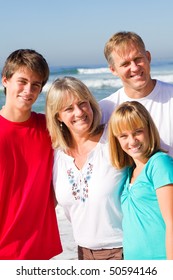 Family Of Four Portrait On Beach