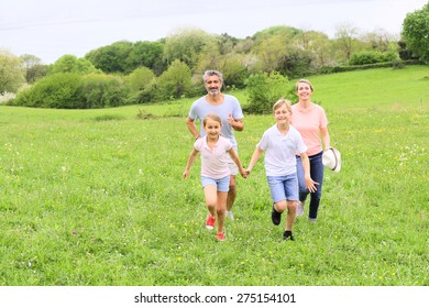 Family of four running in countryside - Shutterstock ID 275154101