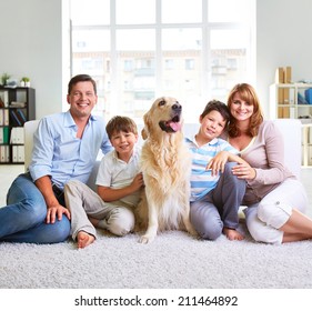 Family Of Four Sitting On Carpet