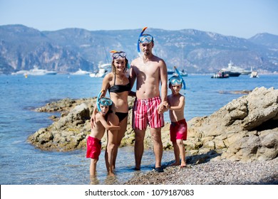 Family Of Four With Swimming Equipment, Ready To Go Diving In The Sea In French Riviera