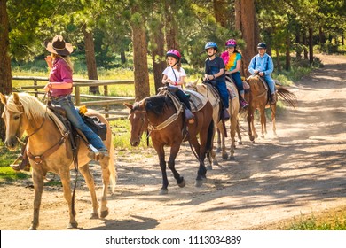 Family of four - two children, their mother and grandfather -- taking a horseback riding  lesson in the woods in the Rocky Mountain, Colorado, USA;  - Shutterstock ID 1113034889