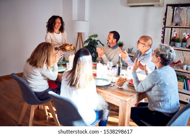Familia y amigos cenando en casa celebrando la víspera de la Navidad con comida tradicional y decoración, mostrando orgullosa cocina de pavo