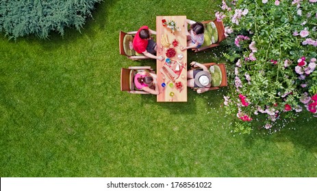 Family And Friends Eating Together Outdoors On Summer Garden Party. Aerial View Of Table With Food And Drinks From Above. Leisure, Holidays And Picnic Concept
