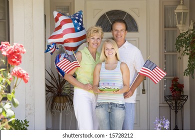 Family At Front Door On Fourth Of July With Flags And Cookies Smiling