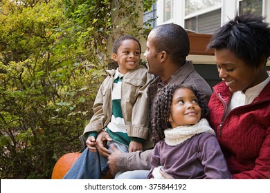 Family In Front Of House