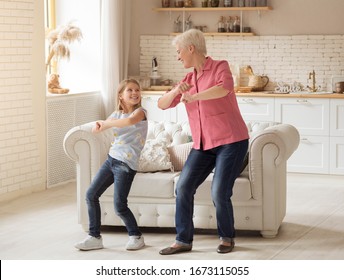 Family Fun. Cheerful Older Lady With Her Granddaughter Dancing At Home