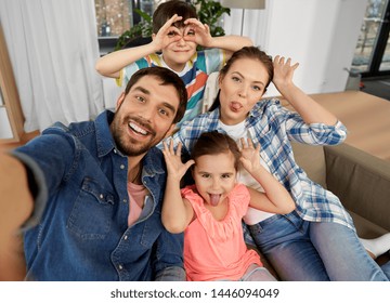 family, fun and people concept - happy father, mother, little son and daughter taking selfie and making faces at home - Powered by Shutterstock