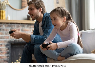 family, gaming and entertainment concept - happy father and little daughter with gamepads playing video game at home. - Powered by Shutterstock