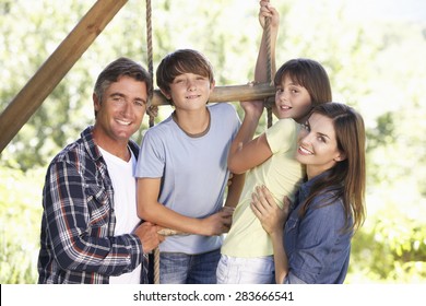 Family In Garden By Treehouse