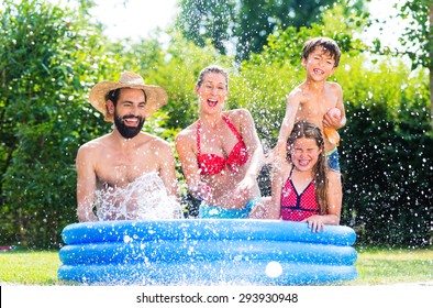 Family In Garden Pool Cooling Down By Splashing Water