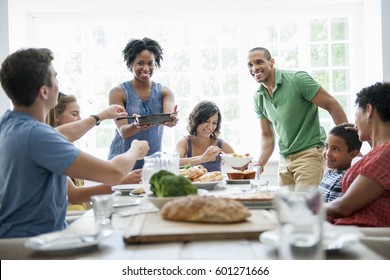 A Family Gathering For A Meal Adults And Children Around A Table