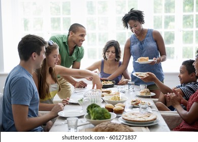 A Family Gathering For A Meal Adults And Children Around A Table