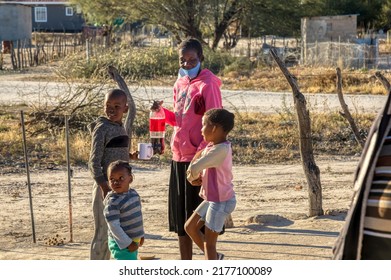 Family Gathering In The Yard,  African Village At Sunset, Girl With Braids Drinking A Cold Drink