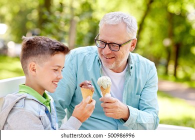 Family, Generation, Communication And People Concept - Happy Grandfather And Grandson Eating Ice Cream At Summer Park