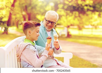 Family, Generation, Communication And People Concept - Happy Grandfather And Grandson Eating Ice Cream At Summer Park