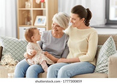 family, generation and female concept - happy smiling mother, baby daughter and grandmother sitting on sofa at home - Powered by Shutterstock