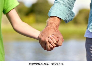 family, generation, support and people concept - senior man and child holding hands