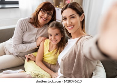 family, generation and technology concept - happy mother, daughter and grandmother taking selfie by smartphone at home - Powered by Shutterstock