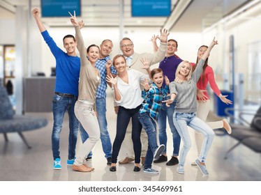 Family, Generation, Travel, Tourism And People Concept - Group Of Happy Men, Women And Boy Having Fun And Waving Hands Over Airport Waiting Room Background