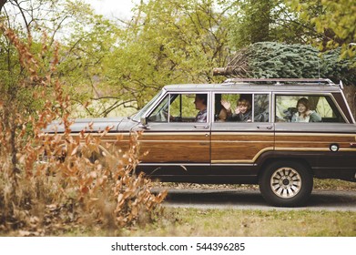 Family Getting A Christmas Tree In A Vintage Car.