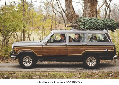 Family Getting A Christmas Tree In A Vintage Car.