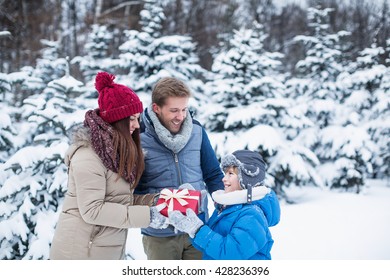 Family With Gift At Winter Forest