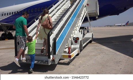 Family Going Up On Airplane Stairs, Parents Holding Child Hands Going Together On Holiday