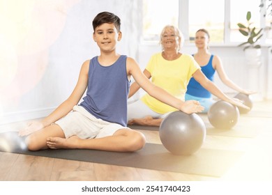 Family grandmother, mother and teen grandson perform fitness exercises sitting - Powered by Shutterstock