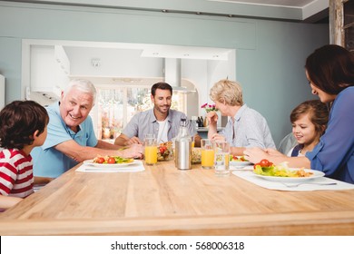 Family With Grandparents Discussing At Dining Table In Home