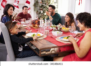 Family With Grandparents Enjoying Christmas Meal At Table