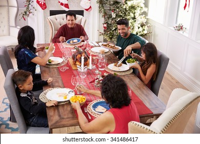 Family With Grandparents Enjoying Christmas Meal At Table