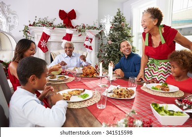 Family With Grandparents Enjoying Christmas Meal At Table