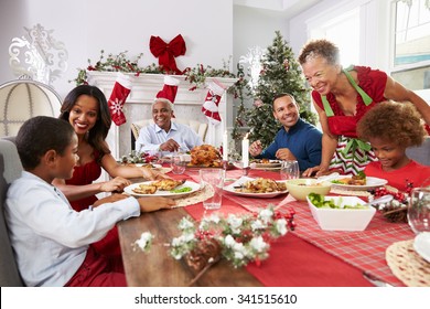 Family With Grandparents Enjoying Christmas Meal At Table