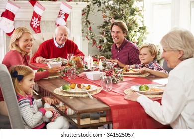 Family With Grandparents Enjoying Christmas Meal At Table