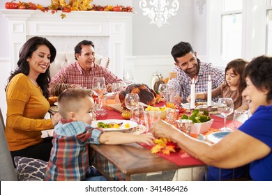 Family With Grandparents Enjoying Thanksgiving Meal At Table