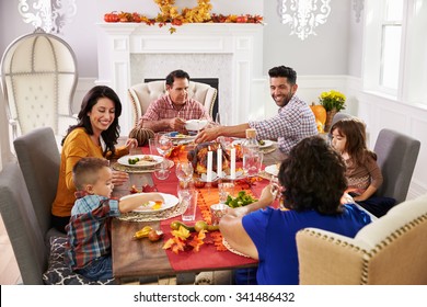 Family With Grandparents Enjoying Thanksgiving Meal At Table