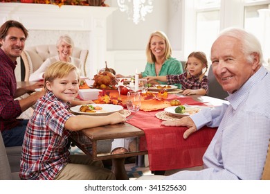 Family With Grandparents Enjoying Thanksgiving Meal At Table